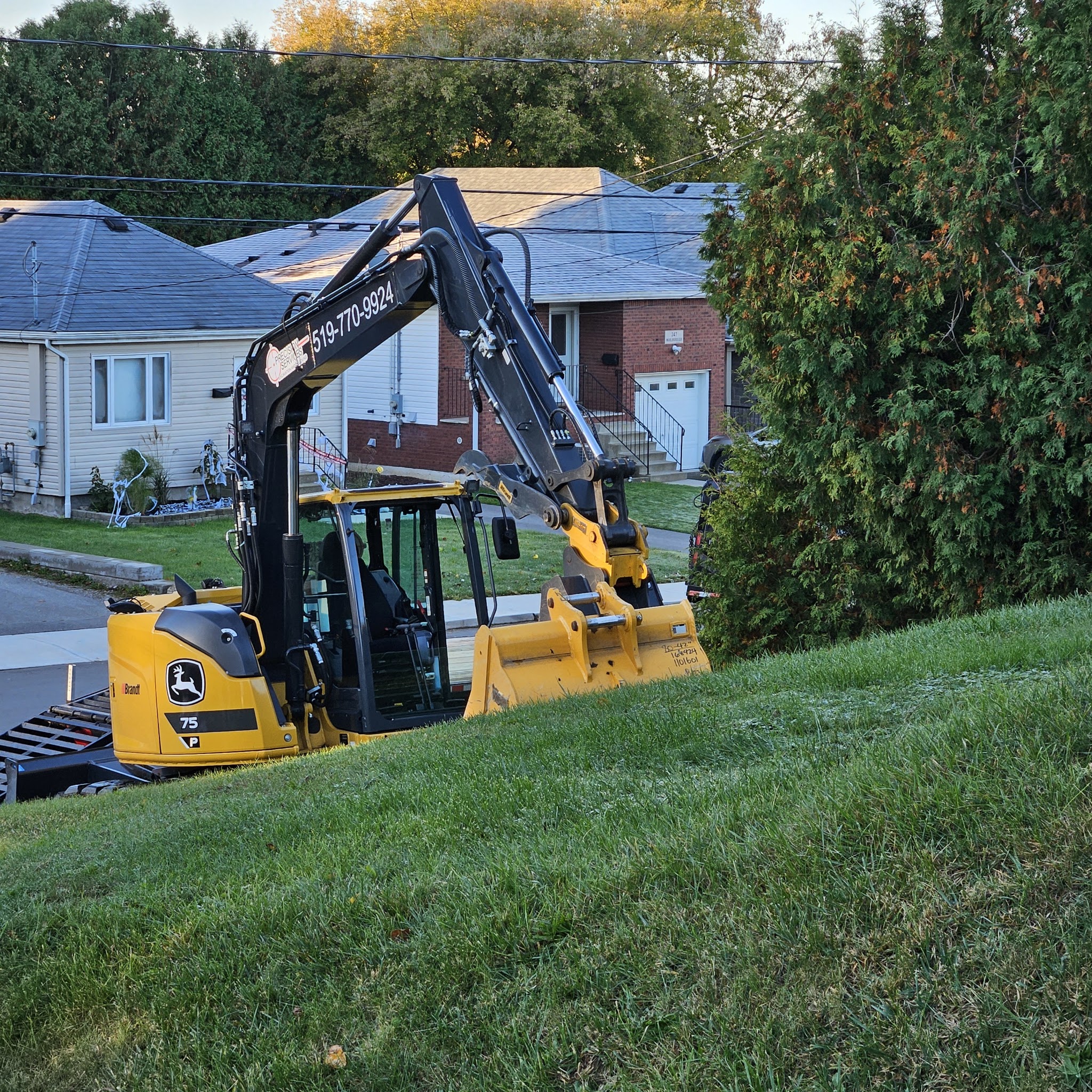 J and A Plumbing's own mini excavator with the company phone number painted on the boom